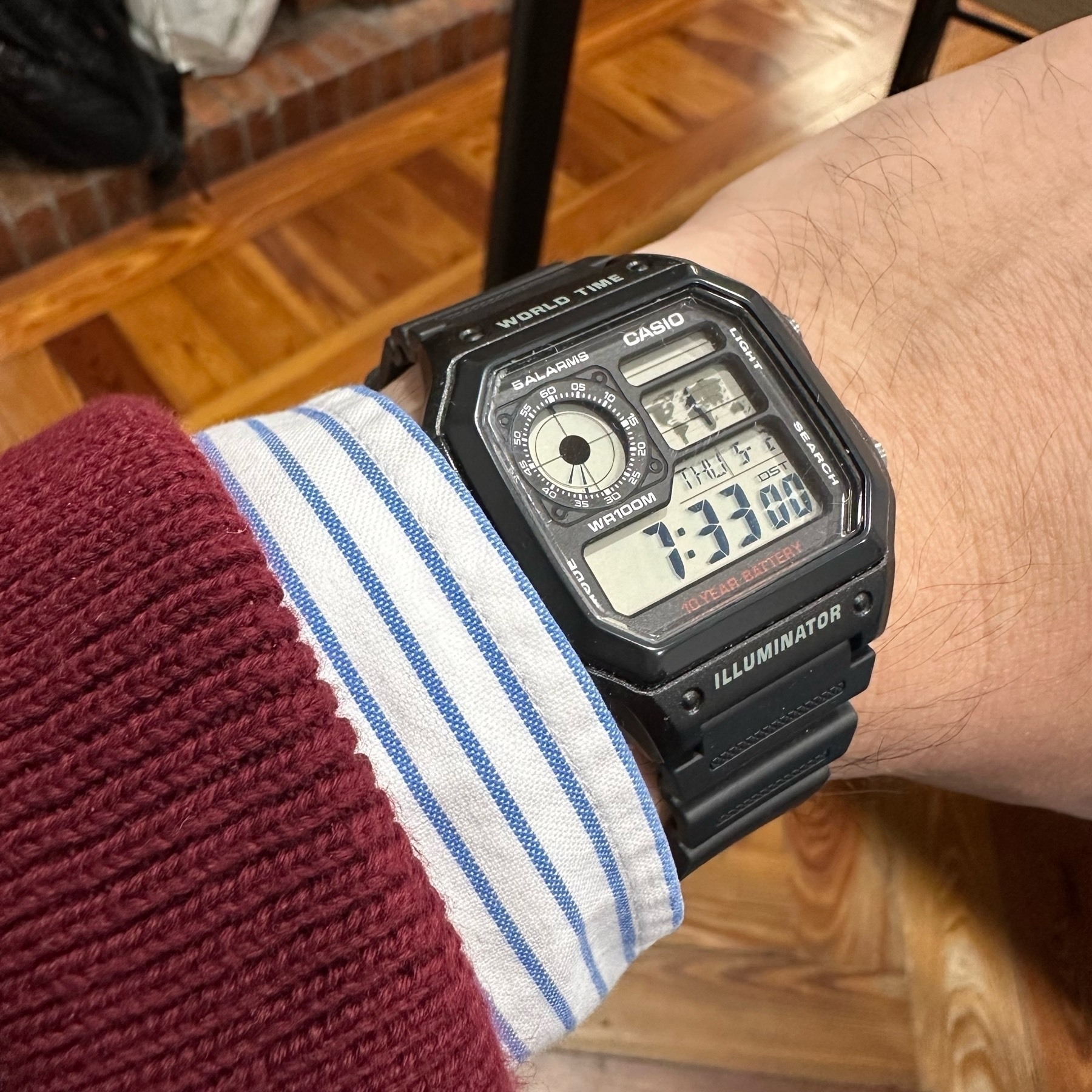 A digital wristwatch displays time on a person's arm, with a background hinting at a casual indoor setting.
Spanish: Un reloj digital muestra la hora en el brazo de una persona, con un fondo que insinúa un ambiente interior informal.
Basque: Erloju digital batek denbora erakusten du pertsona baten besoan, atzealdea lasai barrualdeko giroa iradokitzen duena.