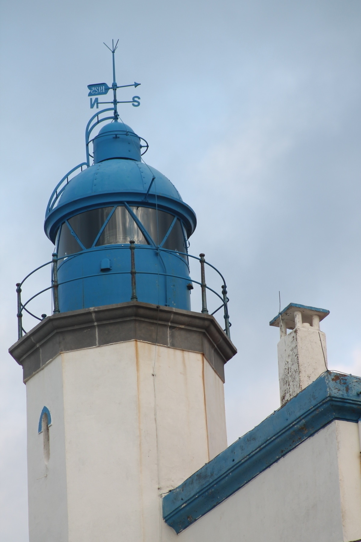 A white lighthouse with a blue top.